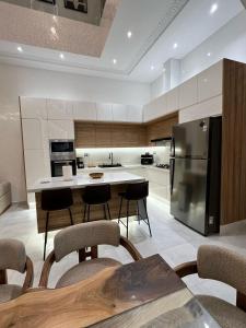 eine Küche mit einem Kühlschrank sowie einem Tisch und Stühlen in der Unterkunft Riad De Luxe Marrakech in Marrakesch