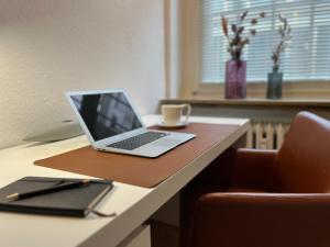 a laptop computer sitting on top of a desk at Modernes City-Apartment mit Highspeed-WLAN & Top-Lage - Easy Stay Wuppertal in Wuppertal
