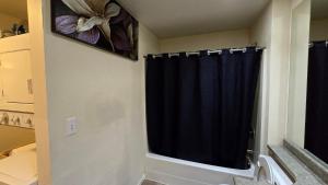 a bathroom with a black shower curtain and a toilet at Lovely 1 Bedroom Condo in the Heart of Seattle! in Seattle