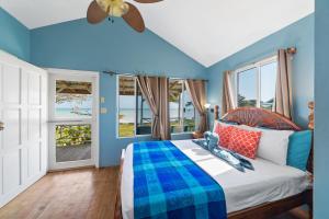 科罗萨尔Tilt-Ta-Dock Resort Belize的一间卧室配有一张蓝色墙壁和窗户的床