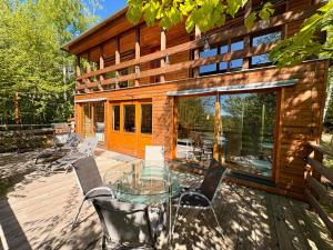 a house with a glass table and chairs on a deck at Domek nad skálou in Kunratice