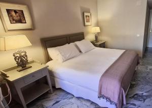 pokój hotelowy z łóżkiem i stolikiem nocnym z łóżkiem o wymiarach 6 x 6 x 6 x w obiekcie Alhambra del Golf - Guadalmina w mieście Estepona