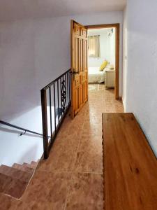 a hallway with a wooden door and a stair case at Casa Rincón de Monda in Monda