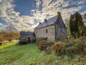 ein altes Steingebäude auf einem Grasfeld in der Unterkunft Splendide MANOIR - Proche plages - 4 chambres - 3sdb - 8 pers - WIFI in Plounérin