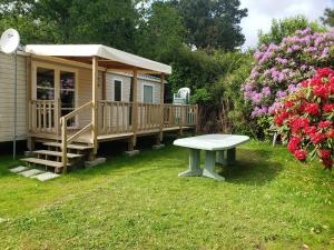 a small house with a bench in the yard at Mobil-home 3 chambres Pont-Aven in Pont-Aven +14 photos