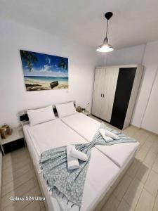 a bedroom with a bed with two white shoes on it at Angelo Apartments in Paralía Avdhíron