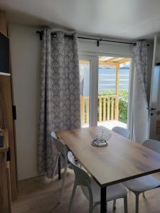 a dining room with a wooden table and chairs at Mobilhome neuf 3 chambres Oléron in Saint-Denis-dʼOléron