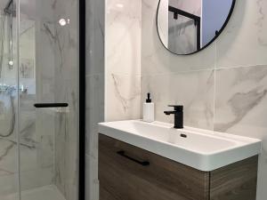 a white bathroom with a sink and a mirror at L'Eden - Spacieux 3P Bord de Mer - Juans les Pins in Antibes +11 photos