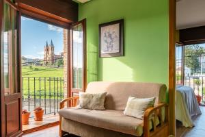 a living room with a couch on a balcony at Apartamentos El Cruce de Moratón in Cóbreces