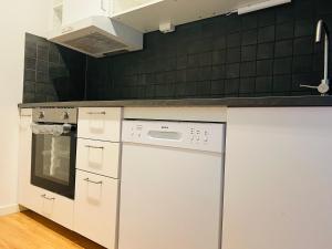 a kitchen with white appliances and green tiles at Comfortable cozy room in Eslöv in Eslöv