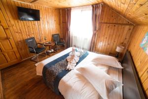 a bedroom with a bed and two chairs and a window at Villa Bravo Breaza in Breaza