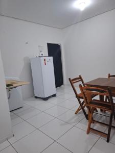 una cocina con una mesa y un refrigerador en my sweet place 8, en São Luís