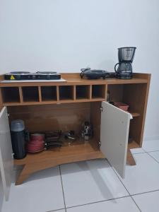 Una cocina con un estante de madera con utensilios de cocina. en my sweet place 8, en São Luís