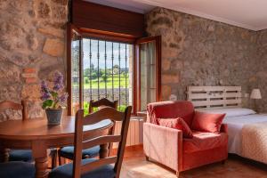 a bedroom with a bed and a table and a chair at Apartamentos El Cruce de Moratón in Cóbreces