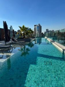 una piscina con sillas y un perfil urbano en Conforto e Estilo em um só Lugar, en Porto Alegre