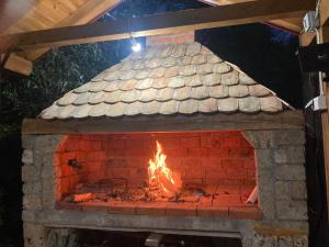 a brick oven with a fire in it at Vikendica na Janju in Šipovo