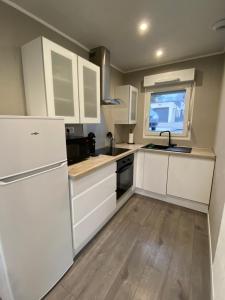 a kitchen with white cabinets and a sink at Maison Bellevue in Creutzwald-la-Croix