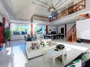 a living room with white furniture and a piano at Medellin Beachvilla 5BR | Billiard | Fiber 100Mbps in Medellin