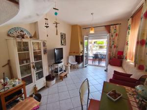 a living room with a couch and a tv at Villa Veta, Nikiti beach in Nikiti