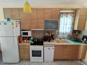a kitchen with a white refrigerator and a sink at Villa Veta, Nikiti beach in Nikiti