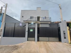 a white house with a gate and a balcony at Pousada do sol in Sorocaba