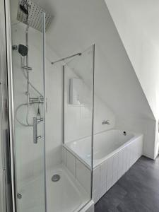 y baño blanco con ducha y bañera. en MaxMir - Ortlohn Iserlohn, en Iserlohn 21 fotos más