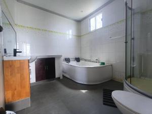 a bathroom with a tub and a shower and a sink at Medellin Beachvilla 5BR | Billiard | Fiber 100Mbps in Medellin +60 photos