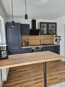 a kitchen with black cabinets and a wooden counter top at MaxMir - Ortlohn Iserlohn in Iserlohn