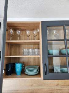 a cabinet filled with glasses and plates and dishes at MaxMir - Ortlohn Iserlohn in Iserlohn +12 photos