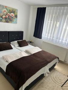 a bedroom with two beds and a window at Apartmani Star in Tuzla +28 photos