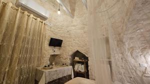 a room with a table and a stone wall at Villa Trullo Septis in Ostuni