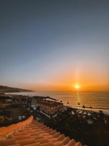 a sunset over the ocean and a beach at Ocean Sky in Candelaria