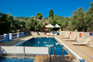 una piscina con sillas y sombrilla en Aretousa Studios & Apartments, en Skopelos Town