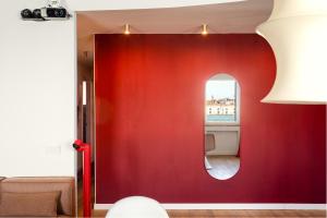 a red wall in a living room with a mirror at 3 Windows on St Mark - Waterfront Apartment in Venice