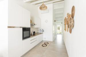 una cocina con electrodomésticos blancos y un pasillo en La Selva - Marlù House -, en Cabras