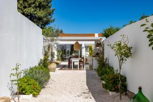 Un patio de una casa con una pared blanca. en La Selva - Marlù House -, en Cabras