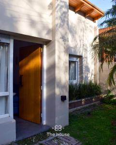 a house with a wooden door on the side of it at The House in City Bell