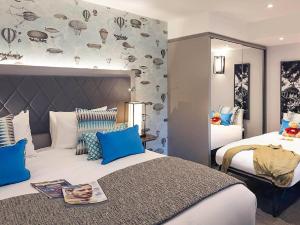 a bedroom with two beds with blue pillows at Hotel CORAL COVEE Near Delhi Airport BY GROSS GROUP in New Delhi