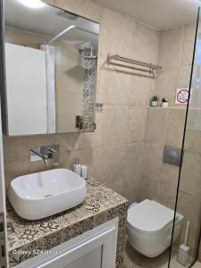 a bathroom with a sink and a toilet at Angelo Apartments in Paralía Avdhíron +27 photos