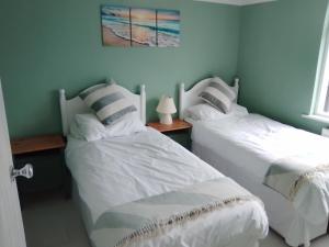 twee bedden naast elkaar in een slaapkamer bij Penzer Cottage in Mousehole