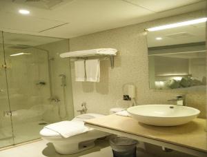 a bathroom with a sink and a toilet and a shower at Hotel CORAL COVEE Near Delhi Airport BY GROSS GROUP in New Delhi