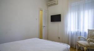 a bedroom with a bed and a tv and a window at Apartment in city center of Belgrade in Belgrade