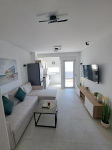 Una sala de estar blanca con un sofá y una mesa. en M&M Luxury Apartments, en Petrčane