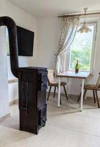 a living room with a tv and a dining room table at Randfichte - die Hütte direkt am Wald in Neudörfel +5 photos