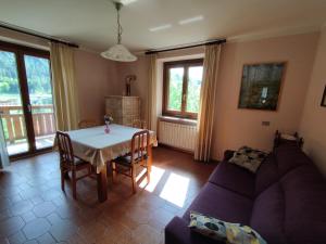 a living room with a table and a couch at Appartamento Sole in Mezzana