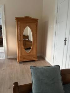 a wooden mirror in a room with a chair at Apartament Ignacy in Brodnica
