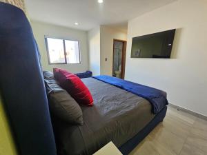 a bedroom with a bed with a couch and a television at Casa Bohemia in Culiacán