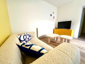 a living room with a couch and a tv at Appartement le Pop Art, à deux pas du Port in Le Tréport