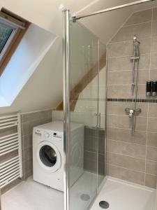 une salle de bain avec une machine à laver et un lave-linge dans l'établissement Gite des 3 sœurs, à Vernon