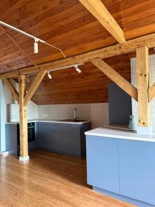 an open kitchen with wooden ceilings and a kitchen island at Przystanek Okrężna in Ząbkowice Śląskie